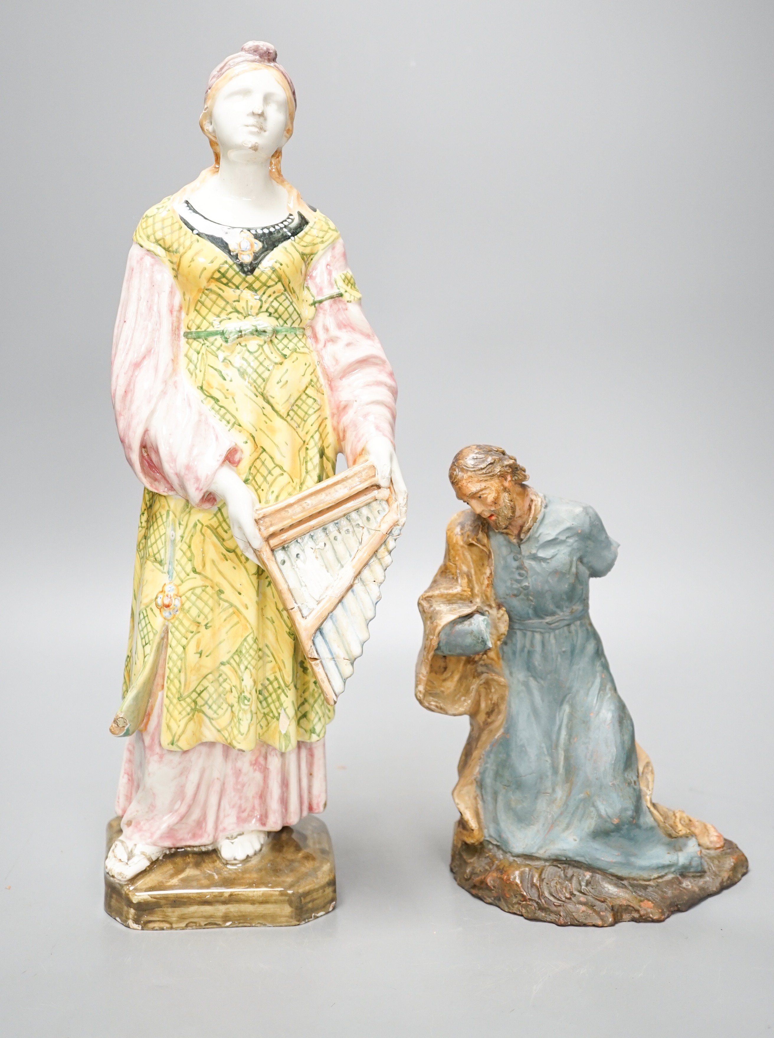 A late 19th century Italian maiolica figure of a Grecian woman or goddess with pipes and Sicilian terracotta figure of a Saint, tallest 38cm